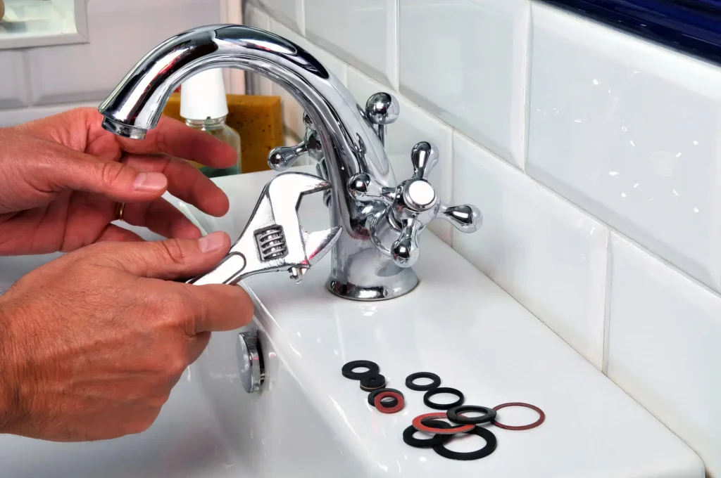 Plumber performing maintenance on a bathroom faucet in Menifee