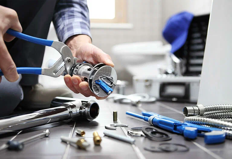 Technician repairing a plumbing fixture with professional tools in Menifee