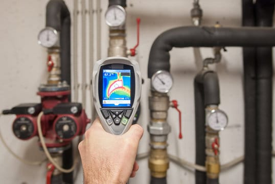 Plumber using a thermal imaging camera to inspect pipes in Menifee
