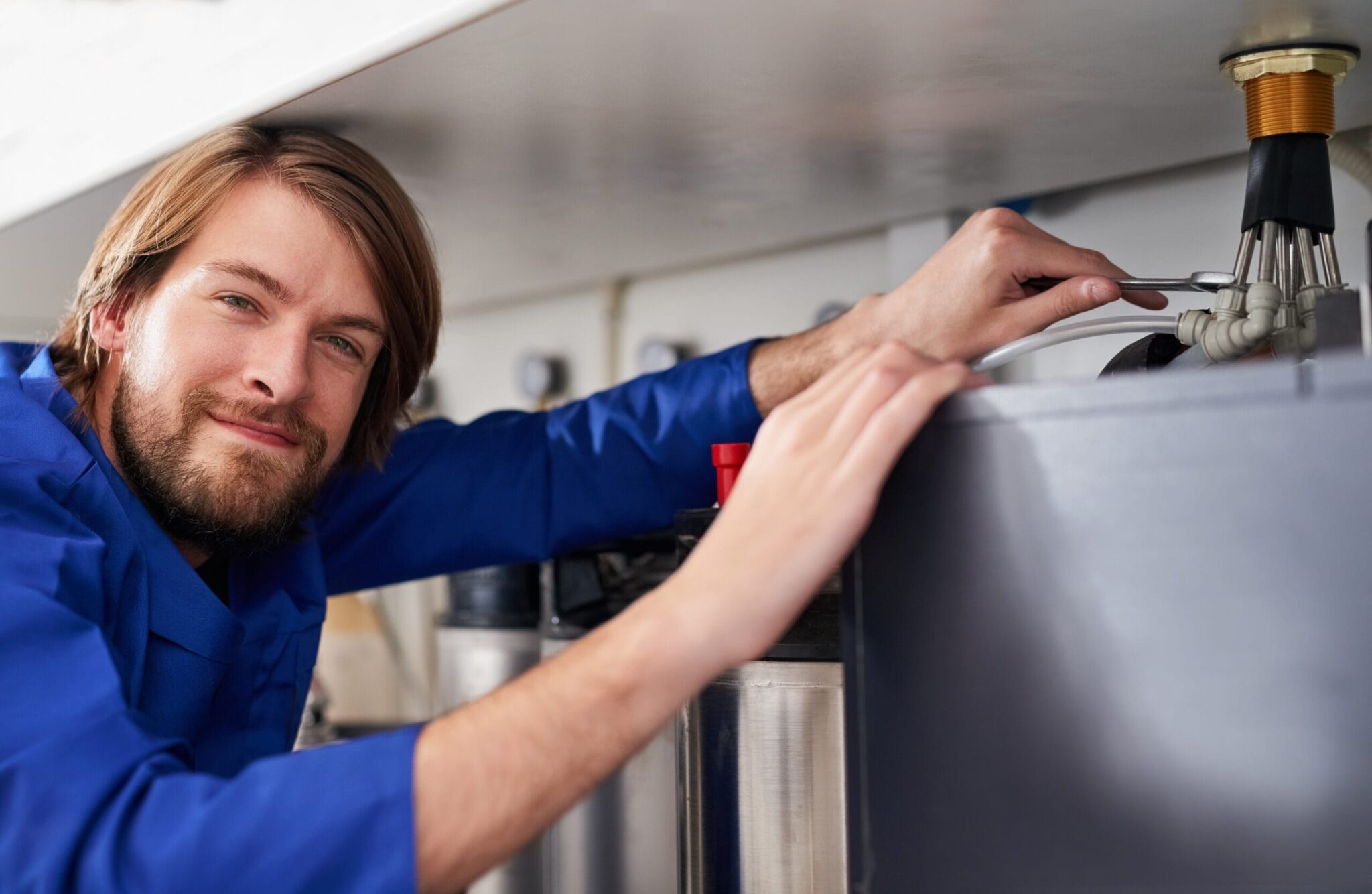 Technician servicing a residential water heater tank in Menifee