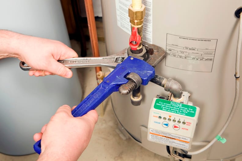 Plumber repairing a water heater valve in Menifee
